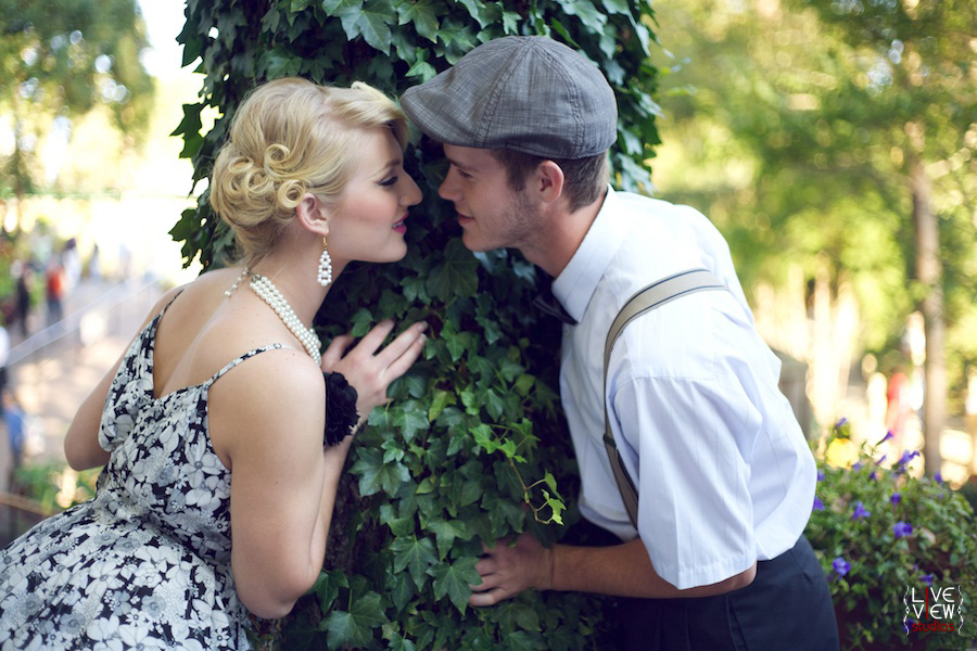 engaged couple kissing at tree covered in vines