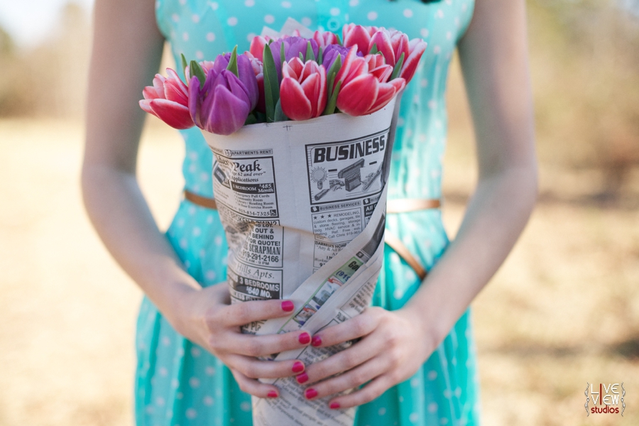 woman holding pink and purple tulips wrapped in newspaper, romantic valentine's day couple's photography