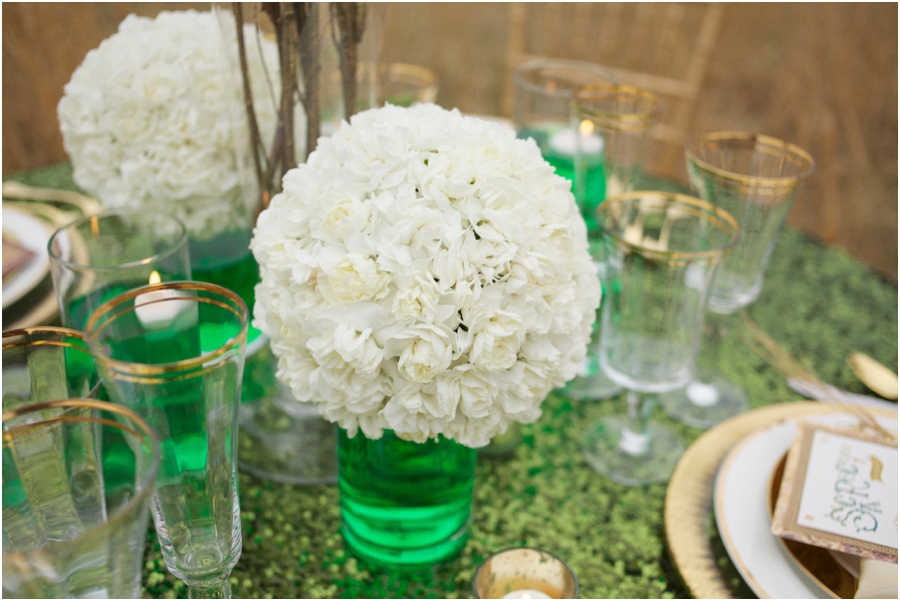white floral pomanders in emerald tinted water on emerald sequin tablecloth, modern wedding reception ideas