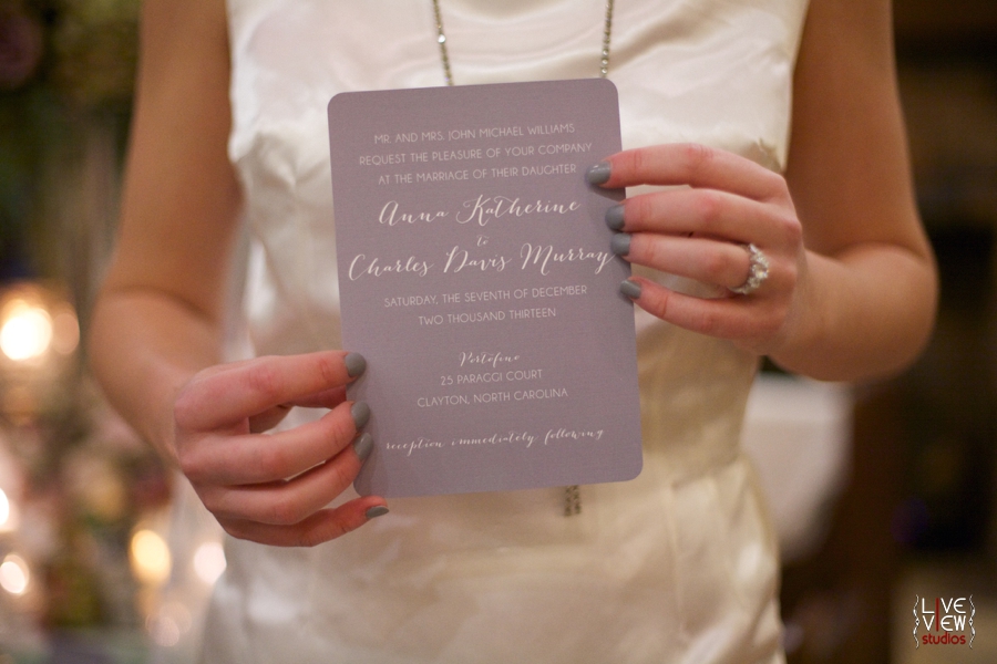 bride holding out wedding invitation, raleigh nc wedding photographers