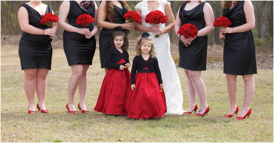 elegant wedding colors, bridesmaids in black gowns from david's bridal and red heels holding fresh red roses, flower girls in pretty black and red dresses