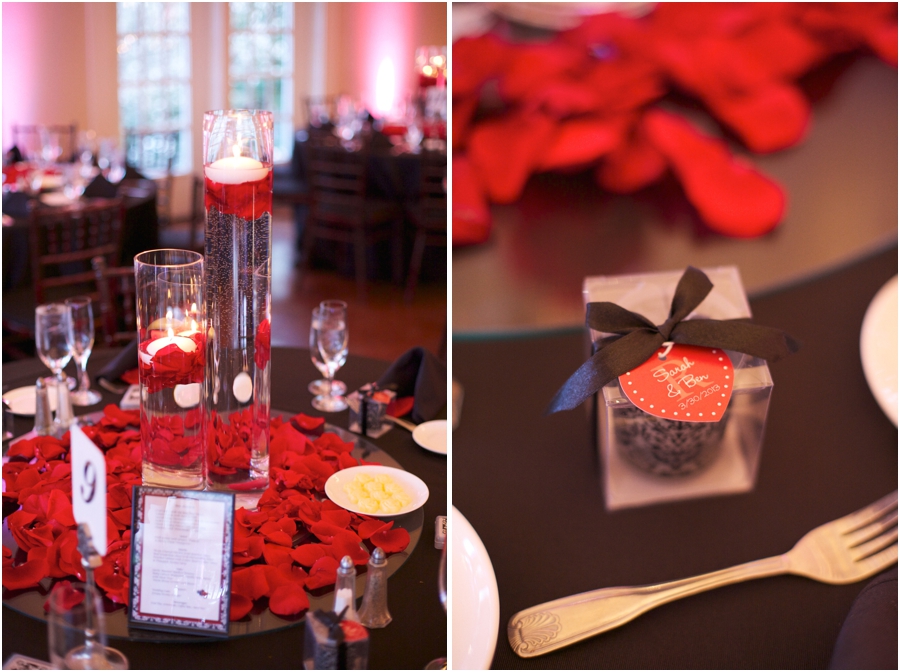 elegant table decor, candles in tall glass vases and red rose petals on black table cloths 