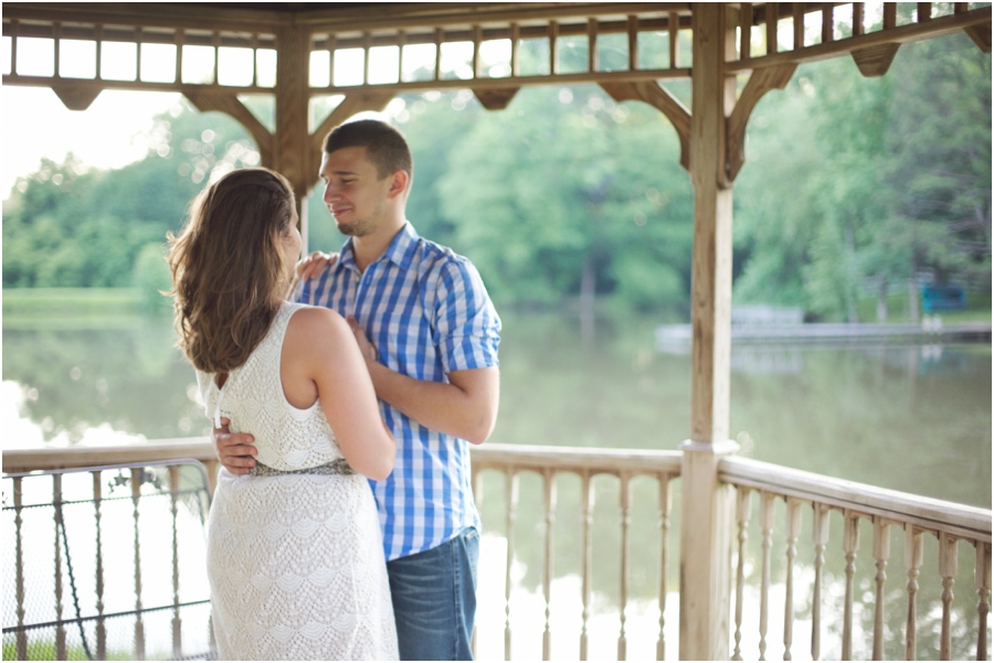 couple dancing in a gazebo next to lake, romantic engagement photography