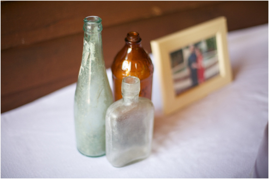 vintage bottles next to pictures of the bride and groom, rustic reception decor, southern wedding photographer, raleigh nc